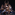 Eleven ballet dancers wearing white pose together on a dark stage.