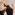 Two dancers in black raise their arms, facing different directions.